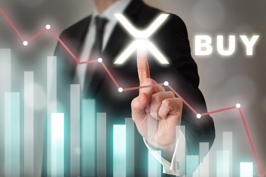 Businessman pressing digital XRP button and digital graphics. Buying XRP when price goes down. 