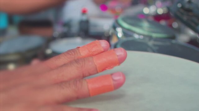 Detail of a musician playing a percussion instrument at a concert.