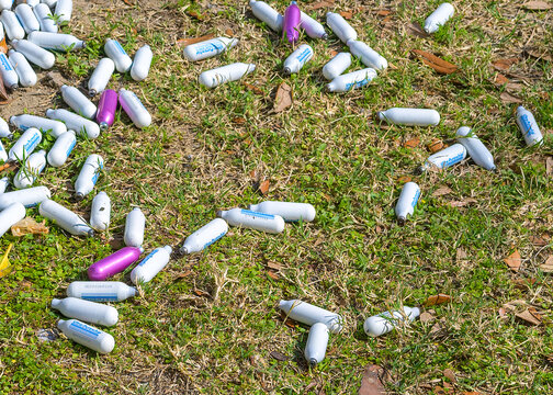 New Orleans, LA, USA - February 21, 2026: Ultra-Purewhip whipped cream (nitrous oxide) charger cartridges discarded on the ground after recreational use by Mardi Gras partyers in the University area