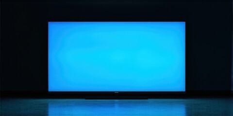 Fototapeta premium Bright screen dominates dark room. Minimalist setup, focus on displays glow. Modern aesthetic, simple composition. Reflective surface below.