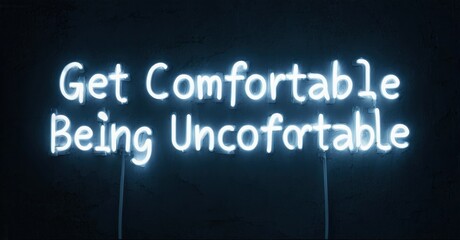 Bright neon sign displays motivational phrase. Dark background emphasizes glowing text, creating striking visual impact. Simple, direct message.