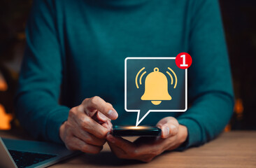 Mobile notification alert concept. Man hands holding smartphone with glowing bell icon and message...