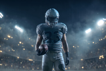 Naklejka premium An American football player stands poised on the field holding a ball at night