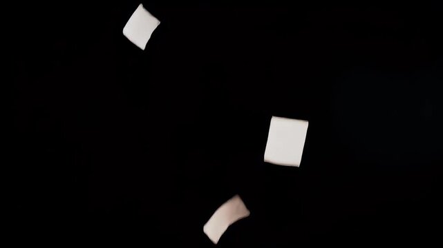 Floating Paper Pieces Against Black Background - Abstract Concept.