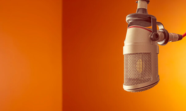 Professional microphone against bright orange background