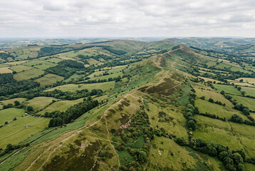 Obraz premium Aerial View of Ridge and Rolling Hills Over Green Countryside With Walking Trails and Valleys