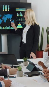 Business concept where good-looking high-skilled successful female expert holding a meeting with concentrated mixed race listeners and telling about ecological problems on earth on interactive screen