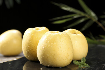 Fresh Golden Yellow Apples with Water Droplets on Dark Slate Background