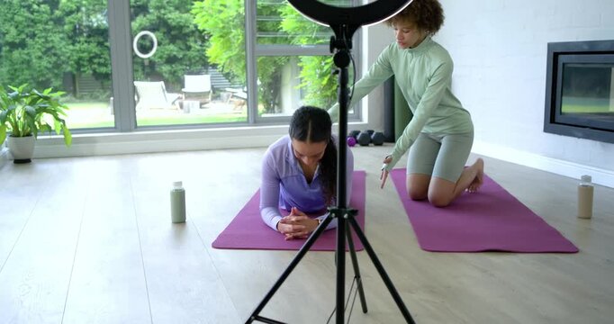African American coach placing hands helping client folding forearm hold on mats checking form