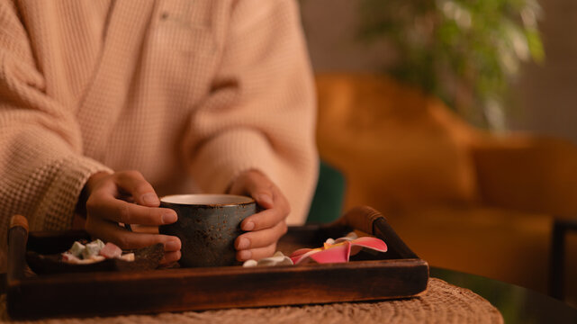 Closeup hand of woman client in Relaxing spa scene with tea ritual in cozy setting, banner