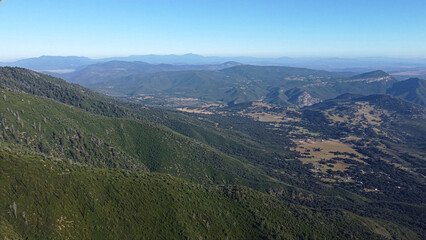 Fototapeta premium Panoramic shot of Palomar Mountain State Park covered in dense pine forests. High-angle view of winding roads, hiking trails, and vast green valleys under the California sun. Wilderness scale.