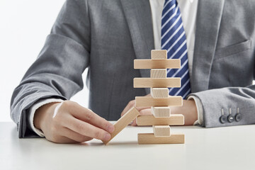 Businessman Playing Wooden Block Tower Game - Risk Management Concept