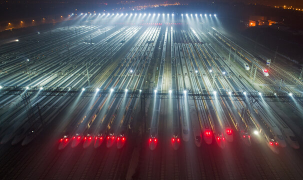 Nighttime Railway Station Aerial View with Illuminated Tracks and Trains