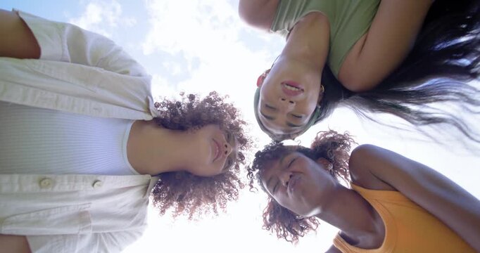African American women friends spotting camera in park leaning over laughing posing for camera