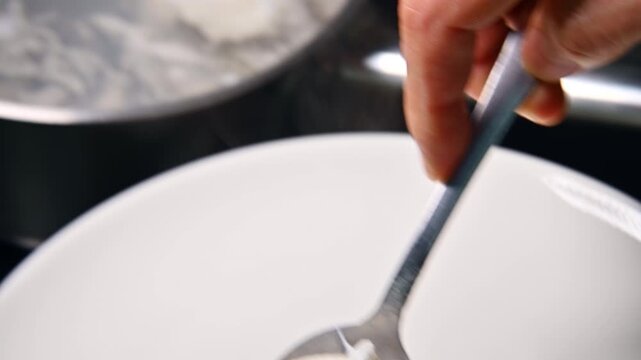Cooking process of poached eggs in a stainless steel pot with boiling water, showing the egg's movement and preparation stages in a kitchen setting