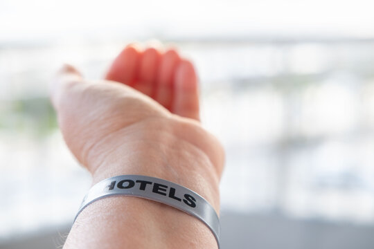 female hand adult beach vacation, wristband hotel resort identifier bracelet on beach, all inclusive vacation shared memories, travel summer holiday, identifier for resort access, security, or payment