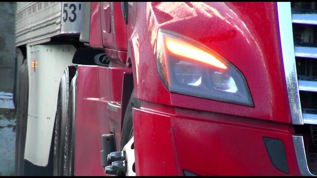 Blinking turn signals on red truck and trailer, close up.