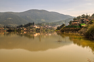 Obraz premium Reflection of Pirincci village from Odemis Bademli Dam lake.