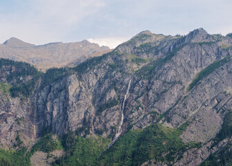 Obraz premium Detailed view of multiple waterfalls cascading down steep rocky mountain walls at Avalanche Lake, Glacier National Park, Montana, USA