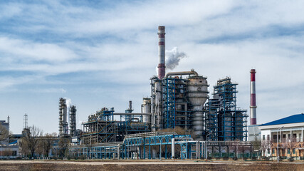 Obraz premium Industrial Petroleum Refinery Exterior View with Smokestacks
