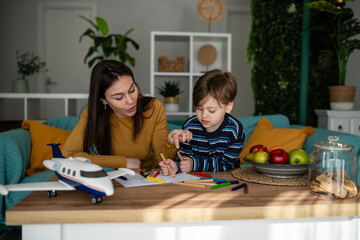 Mother helping son learning drawing at home