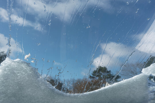 Letzter Schnee mit Sonne liegt auf dem Dachfenster