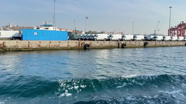 Logistics and shipping operations at Haydarpasa Port in Istanbul, Turkey. Rows of trailers at the ro-ro terminal with a blue building on the pier against the Bosphorus water. Industrial maritime scene