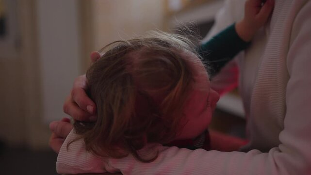 Mother gently caressing frustrated toddler who seeks breastfeeding, intimate parenting moment of negotiation, emotion and attachment during weaning process at home