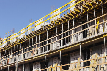 Apartment block under construction with concrete floors and wooden formwork. Residential building development with scaffolding and reinforced structure. Urban housing project and real estate growth. © Paweł Michałowski