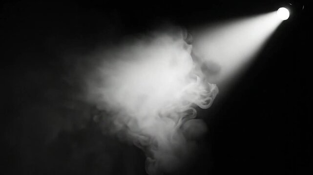 A single bright light illuminates a cloud of smoke against a dark background