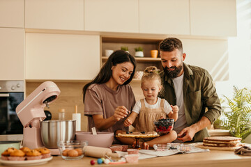 Family enjoying time baking and decorating a cake