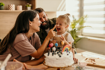 Loving family celebrating birthday with cake and laughter