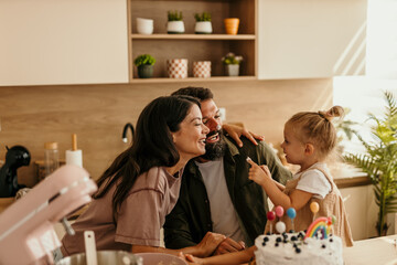 Young family celebrating birthday with homemade cake