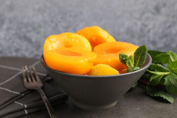 Pickled peaches and mint leaves on grey table, closeup © New Africa