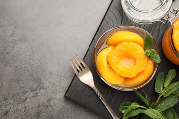 Pickled peaches and mint leaves on grey table, flat lay. Space for text © New Africa