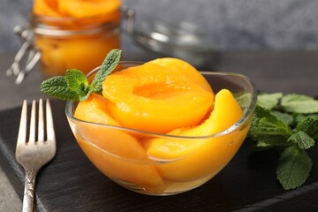 Pickled peaches and mint leaves on grey table, closeup © New Africa