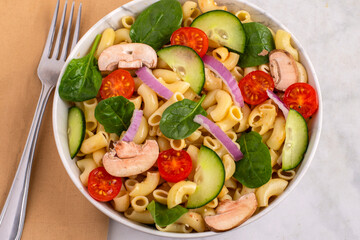 macaroni top with  tomato,  spinach  and cucumbers