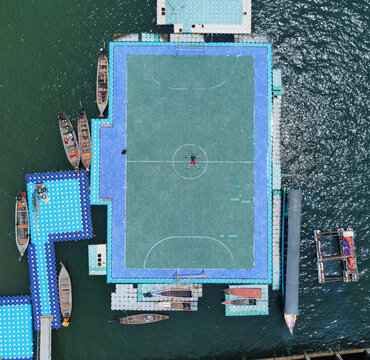 Aerial view of a vibrant floating soccer field on the water, a testament to innovative recreation, Khao lak, Phang Nga, Thailand.