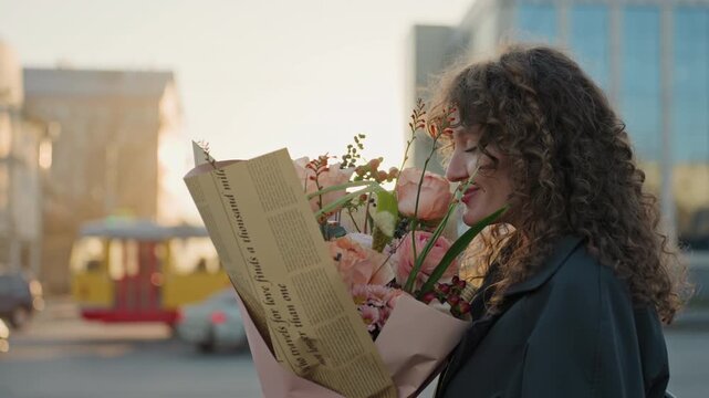 Blooming shopkeeper with evening city skyline. Smile graces florist holding roses beneath glowing city lights. Cheerful flower seller showcasing bouquet with vibrant cityscape lighting behind