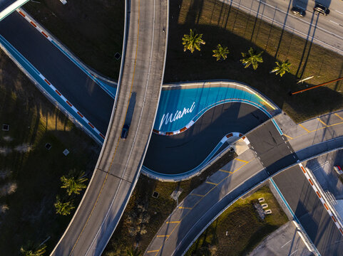 Miami Gardens, USA - 23 February 2026: Aerial view of the vibrant Hard Rock Stadium area, where the track's bold curves and the city's name stand out against the backdrop of palm trees and roads.