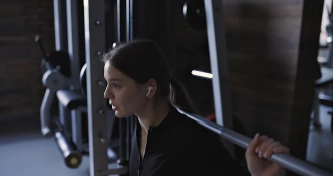 Smith machine squats, woman at the gym, slow motion