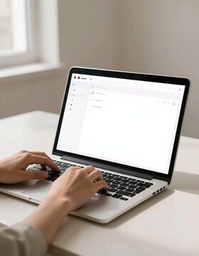 hands typing on a laptop on a desk