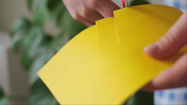 Close up of hands cutting yellow paper strips with scissors developing fine motor skills and creative art therapy learning