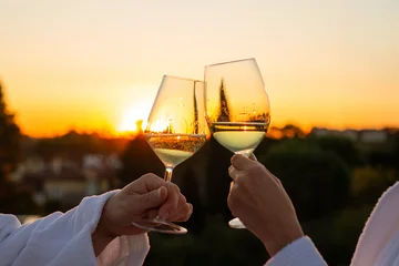 Fototapete Wein Couple toasts white wine sunset rooftop hotel bathrobe, romantic aperitif luxury celebration toast golden hour sunset romantic getaway  © Travel Studio Stock