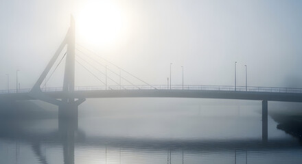 Fototapeta premium A golden suspension bridge tower rises above the foggy river water, showcasing landmark steel engineering and architecture on a travel road between the city bay and the sea