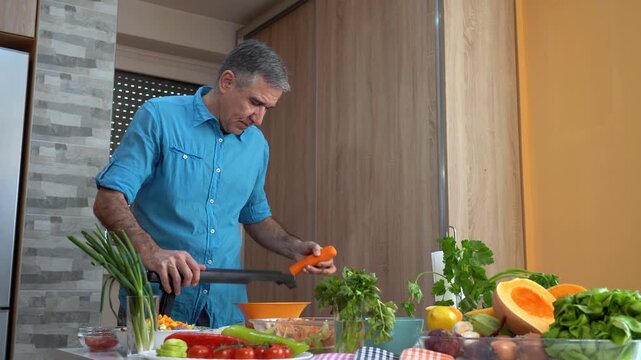 Fit Mature Man Using Mandoline Slicer for Organic Carrots at Home. High-quality vegetarian cooking and healthy lifestyle concept.
Search VITAL-CHEF54 for more from this collection.