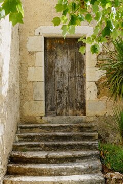 Old wooden door worn out by the passage of time and staircase to the house