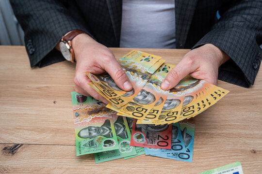 Businessman Hands Counting Fifty Australian Dollar Banknotes for Budget Planning and Savings
