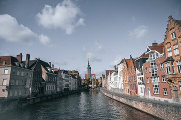 Naklejka premium Scenic canals and historic medieval architecture in Bruges, Belgium, featuring traditional Flemish buildings along the water in the iconic European city.
