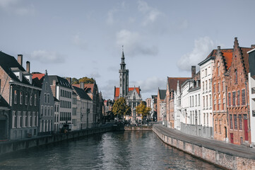 Naklejka premium Scenic canals and historic medieval architecture in Bruges, Belgium, featuring traditional Flemish buildings along the water in the iconic European city.